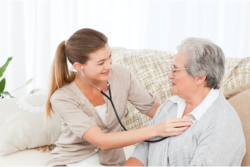 caregiver checking hearbeat of an elderly woman