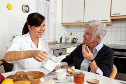 caregiver serving meal to elderly patient